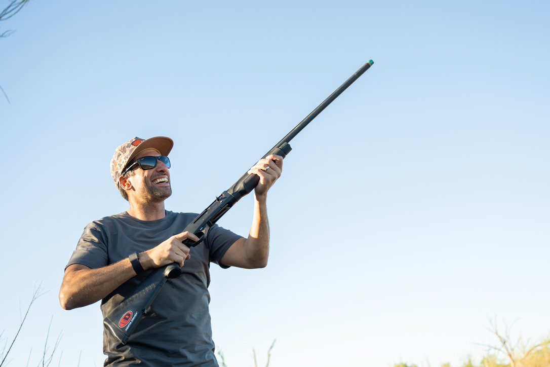 a bird hunter smiling after a great shot and kill 